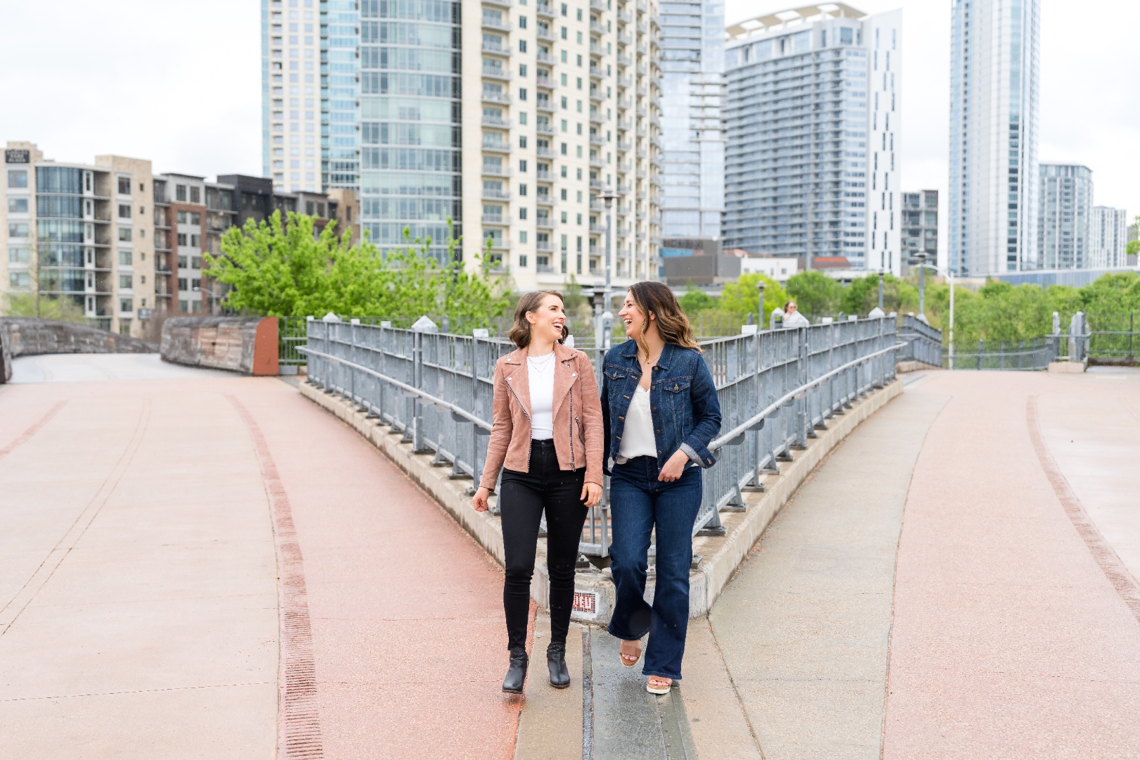 Robin Welch and Deborah Andrews walking together across an Austin pedestrian bridge