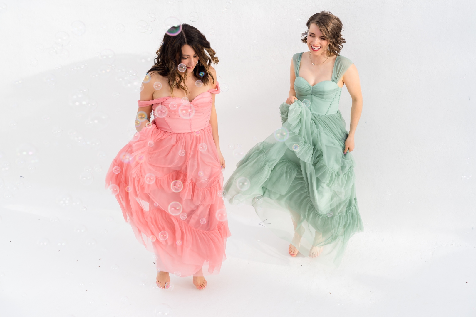 Robin Welch and Deborah Andrews walking through bubbles, laughing together